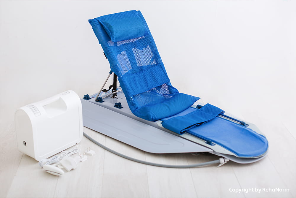 Blaue Badehilfe mit Rückenstütze, Liegefläche und elektrischem Antrieb auf hellem Hintergrund