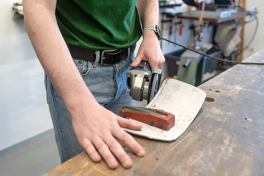 Mitarbeiter bereitet in der Werkstatt ein Werkstück mit Werkzeug und Markierungen für die weitere Bearbeitung vor