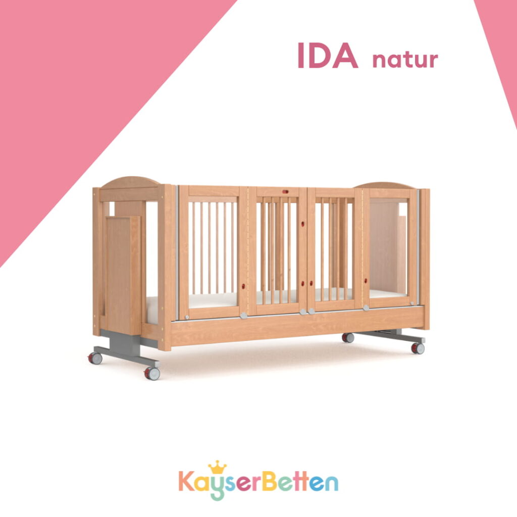 Naturfarbenes Kinder-Pflegebett Ida mit hohen Seitengittern, Rollen und stabiler Holzkonstruktion