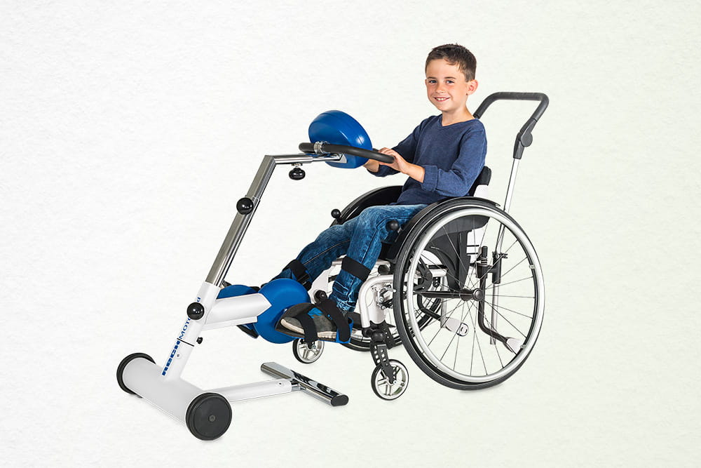 Ein Junge nutzt in seinem Rollstuhl einen Bewegungstrainer für die Beine.