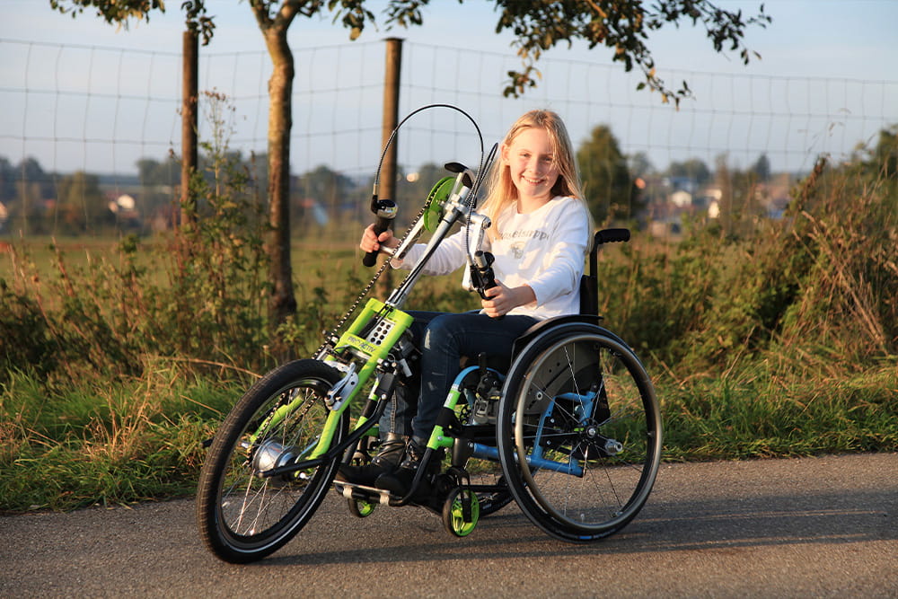 Ein Mädchen mit Rollstuhl nutzt einen Frontradantrieb, wodurch sie elektrisch fahren kann.