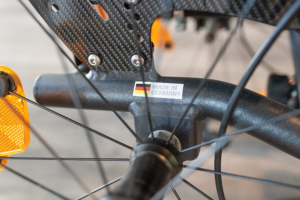 Nahaufnahme eines Rollstuhlbauteils mit Aufkleber Made in Germany und Carbon-Elementen